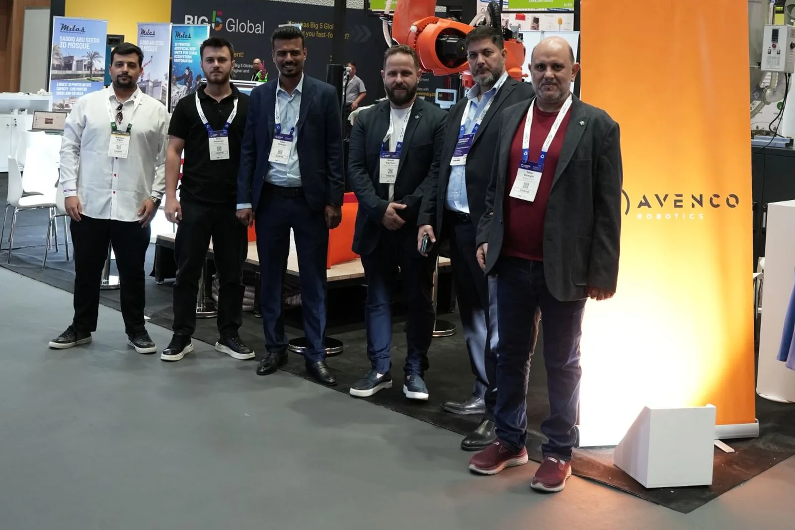 The Miles and AVENCO teams at The Big 5 in Dubai, standing in front of the robotic concrete printing arm on the AVENCO stand