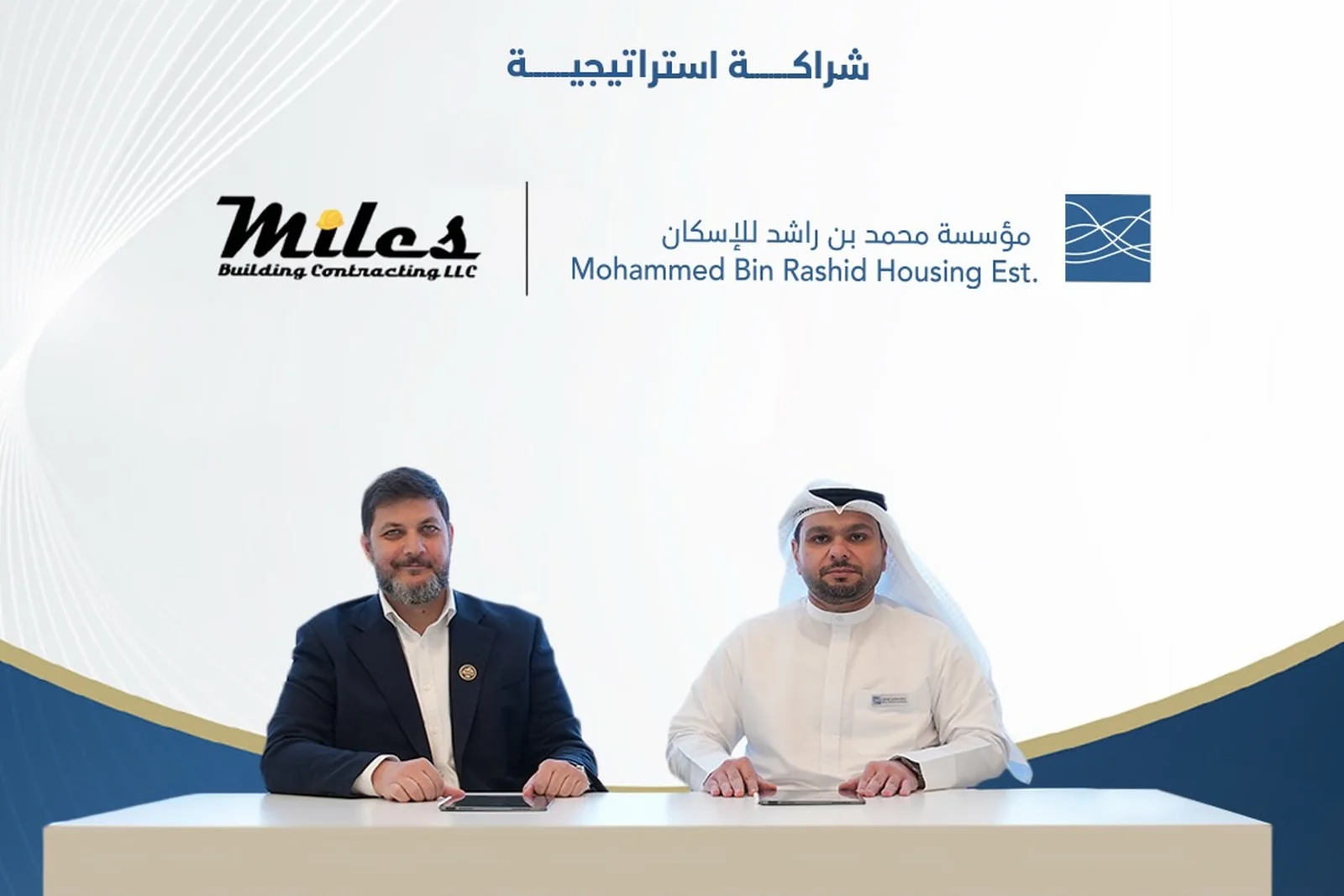Representatives of Miles Building Contracting and Mohammed Bin Rashid Housing Establishment seated at the signing table, in front of a backdrop carrying both organisations' logos