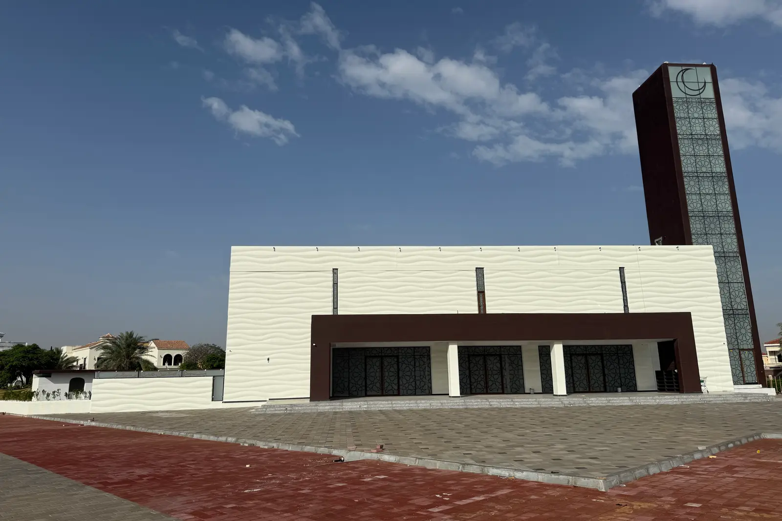 Saddiq Mosque in The Villa — front elevation with the printed wave-textured walls and the minaret