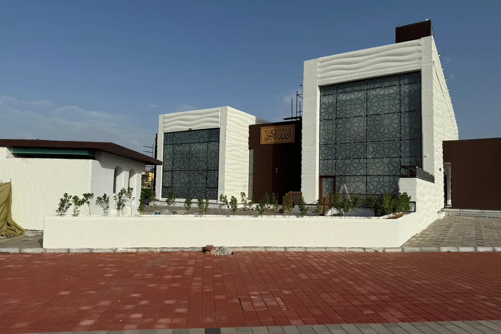 Saddiq Mosque in daylight, the printed wave texture running across the facade