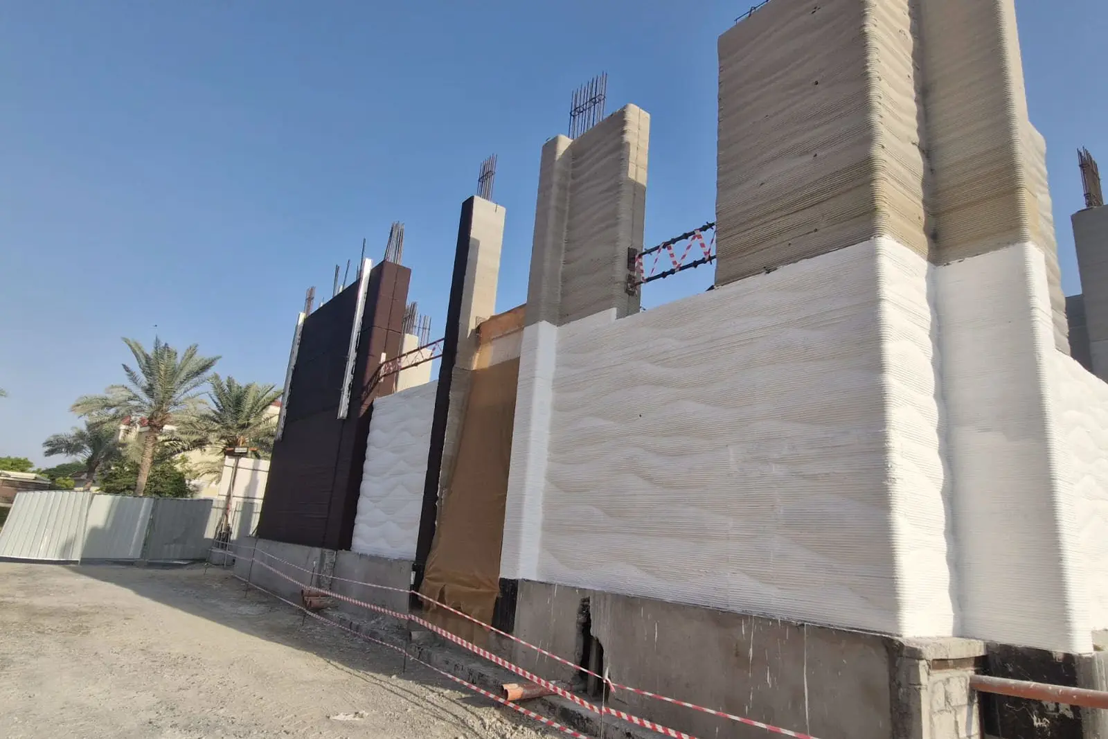 Printed walls standing on site, showing the layered surface the process leaves