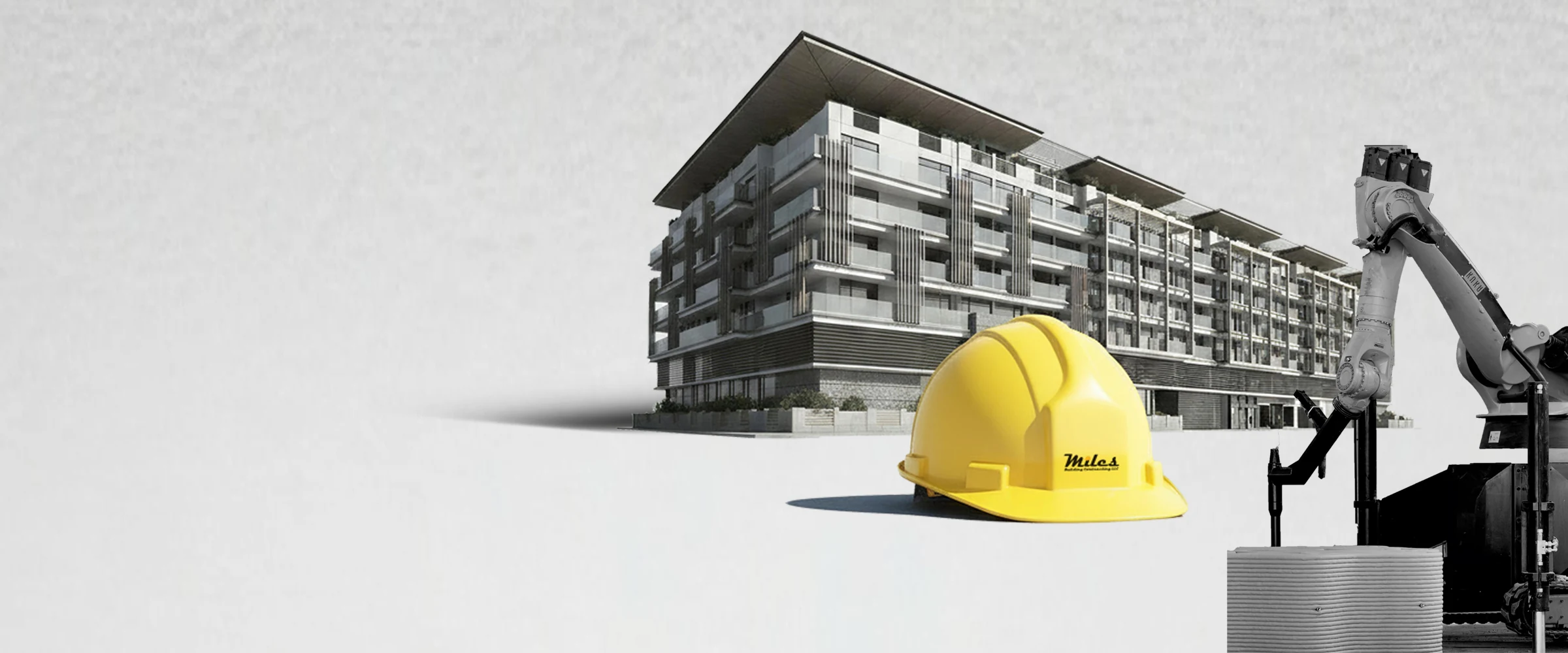 A Miles residential building alongside a concrete printing robot arm and a printed concrete column, with a Miles branded hard hat in the foreground